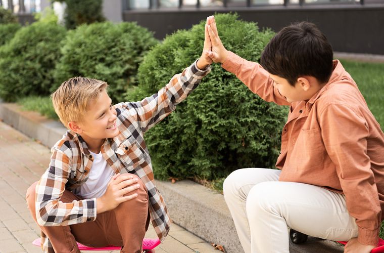 Dos niños celebran juntos chocando las manos