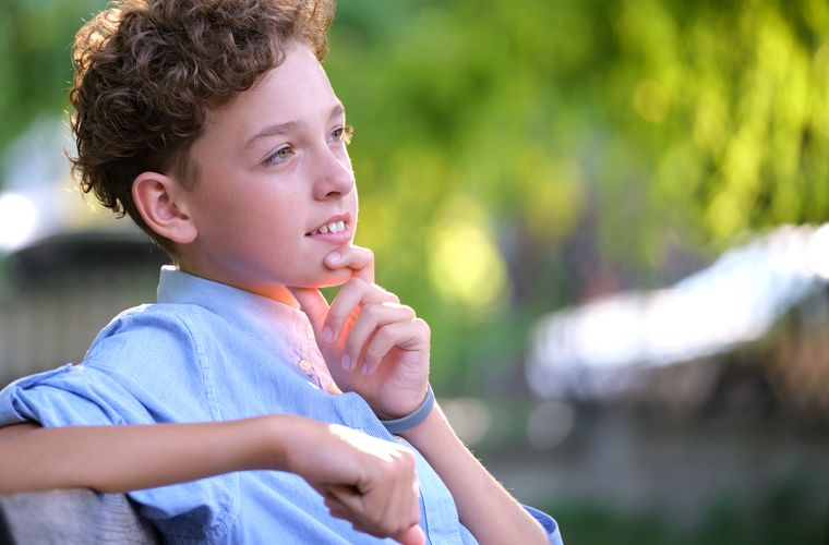 Un niño piensa con calma al aire libre